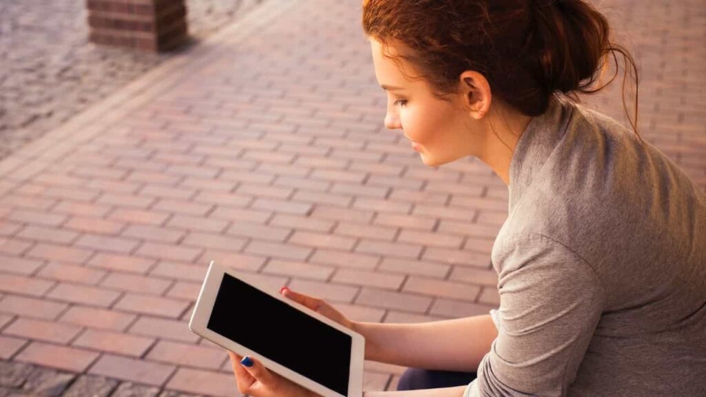 Professional looking at a tablet to illustrate performing a LinkedIn Profile Update.