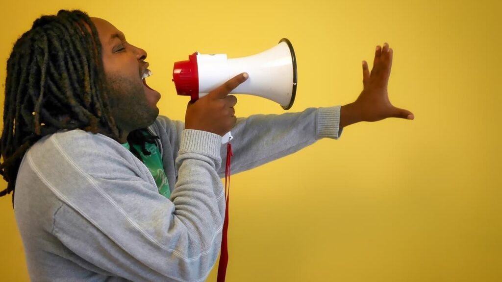 Person on a megaphone to illustrate a blog post about content promotion ideas.